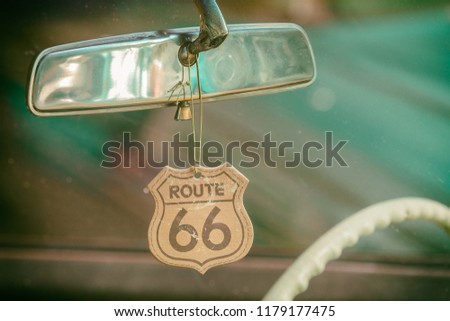 Route 66 badge hanging on a car mirror of a classic car