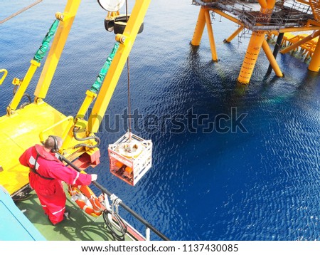 ROV crew deploys inspection class ROV into the sea next to wellhead platform.