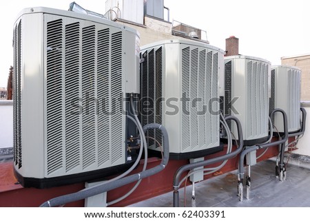 A row of air conditioning units on a rooftop.