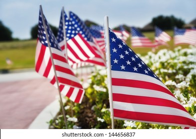 Row of American flags displayed on the street side in celebration of the 4th of July, shallow depth of field