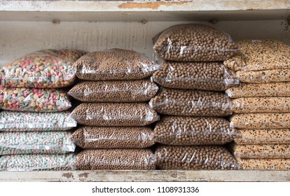 Row Of Animal Feed Pack Or Cereal And Grain Bags For Pets On Shelf In Shop