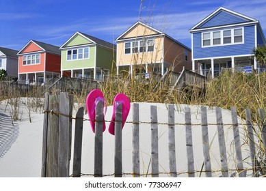 Row of beach rentals on a summer day, pink flip flops on beach fence - Powered by Shutterstock