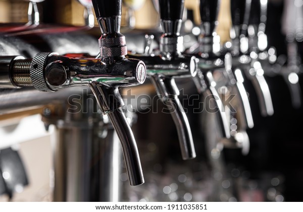 A row of beer taps in a beer
bar close-up. Beer bottling in the restaurant. The bar
counter.