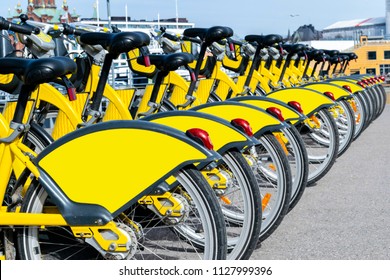 Row of bicycles parked. Row of parked colorful bicycles. Rental yellow bicycles. Pattern of vintage bicycles bikes for rent on sidewalk. Close up of wheel. - Powered by Shutterstock