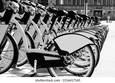 Row of bicycles parked. Row of parked colorful bicycles. Rental bicycles. Pattern of vintage bicycles bikes for rent on sidewalk. Close up of wheel. Soft lighting. Black and white - Powered by Shutterstock