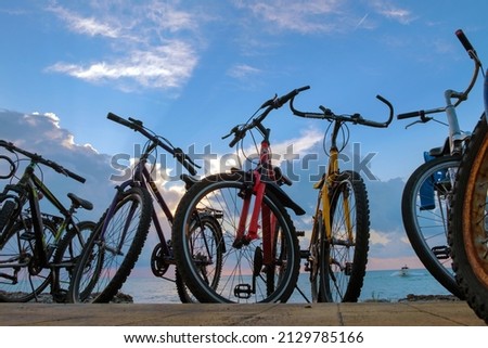 The row of bikes on the beach wit blue cloudy sky background