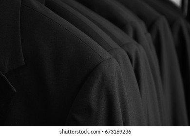 Row Of Black Tuxedo Dinner Jackets In Closet