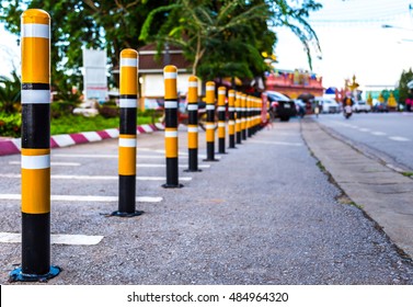 A row of black and yellow metal barrier on the road