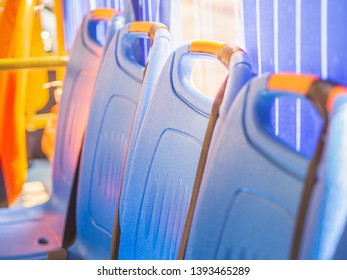 A Row Of Blue Plastic Chairs With Yellow Sunlight On Electric Shuttle Bus In University. Environmental Friendly Concept.