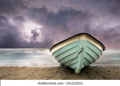 Row Boat On Sandy Beach With Purple Sky