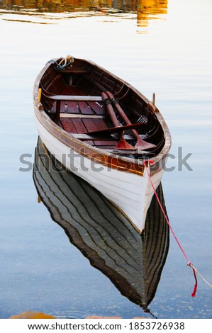 Row boat on very clear sea and its reflection