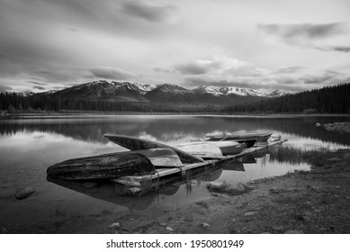 Row boats piled up on a dock in Jasper National Park, shot in black and white. - Powered by Shutterstock