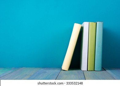 Row Of Books, Grungy Blue Background, Free Copy Space Vintage Old Hardback Books On Wooden Shelf On The Deck Table, No Labels, Blank Spine. Back To School. Education Background