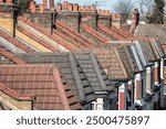 Row of brick chimneys and dormer rooftop in Victorian terraced houses in London