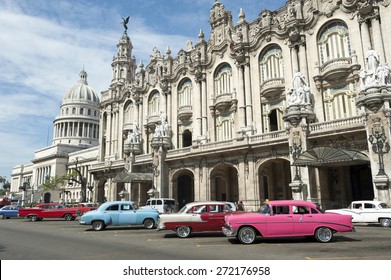 Row of brightly colored vintage American cars stand parked on the street in front of the Galician Palace on Prado Street in central Havana Cuba 