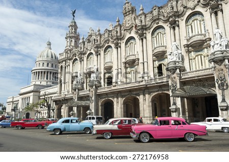 Row of brightly colored vintage American cars stand parked on the street in front of the Galician Palace on Prado Street in central Havana Cuba 
