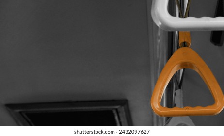 A row of bus handrails. The striking yellow handrail stands out prominently against a backdrop of black and white surroundings. - Powered by Shutterstock