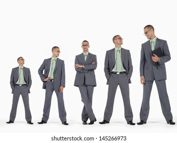 Row of businessmen in ascending order of height against white background