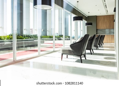 Row Of Chairs In Executive Office Waiting Room. Background Outdoor Modern Lobby Big Window And Blue Sky With Clouds.