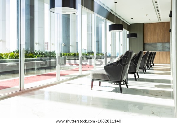 Row of\
chairs in executive office waiting room. background outdoor modern\
lobby big window and blue sky with\
clouds.