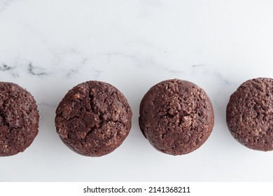 The row of chocolate muffins on a white table - Shutterstock ID 2141368211