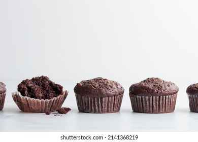 The row of chocolate muffins on a white table - Shutterstock ID 2141368219