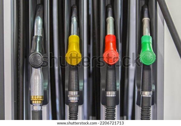 Row of colorful gas pump nozzles at a filling\
station, mechanical hand operated fuel refilling dispensing unit, \
self service petrol fuel refill, Liquefied Petroleum Gas (LPG or\
LP) flammable mixture