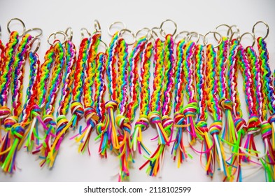 A row of colorful key chains made from plastic craft strings