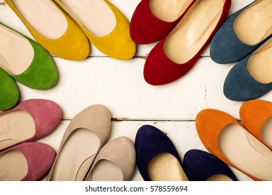 Row Of Colorful Shoes (ballerinas) On A White Wooden Background. Selective Focus