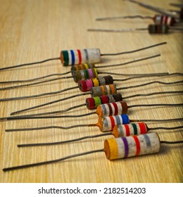 A Row Of Colorful Vintage Electronic Resistors Lined Up On A Wooden Workbench.