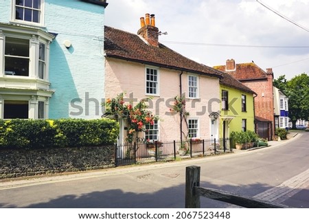 A row of colourful teeraced cottages. Brightly painted small cottage homes in English village.