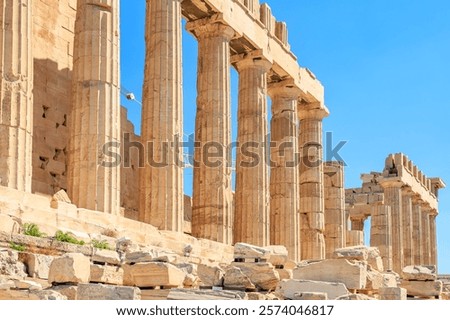 A row of columns in a building, with a blue sky in the background. The columns are made of stone and are arranged in a straight line. The building appears to be ancient