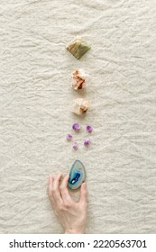 Row Of Crystals On Table, Woman Hand Holding Healing Minerals Agate, Quartz, Amethyst, Onyx, Semiprecious Gem. Stones For Stone Therapy, Lithotherapy, Rock For Ritual. Top View, Flat Lay With Daylight