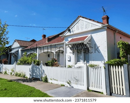 Row of detached bungalow homes in the residential suburb of St Kilda in Melbourne. Traditionally built bungalows in the 20th century Australian style with a porch, ornate verandah and garden gate.