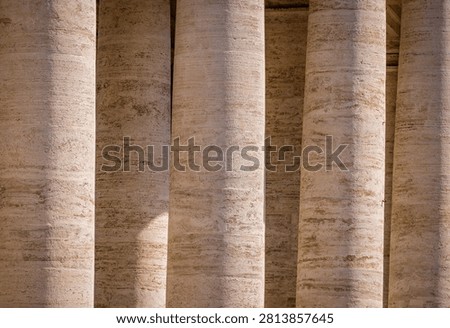 Row of detailed marble columns casting shadows, forming a rhythmic pattern at Saint Peter's Basilica, Vatican City