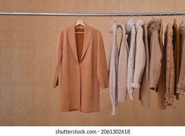 Fila de punto marrón y caliente diferente en otoño de percha, chaqueta, abrigo de fondo de madera de invierno

