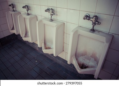 A Row Of Dirty Urinals In Tiled Wall In A Public Restroom Focusing, Process Color