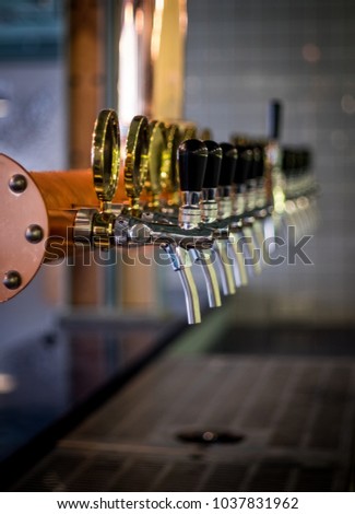 Row of draft beer tab on the top of counter bar in closeup view, time of celebration, selective focus.