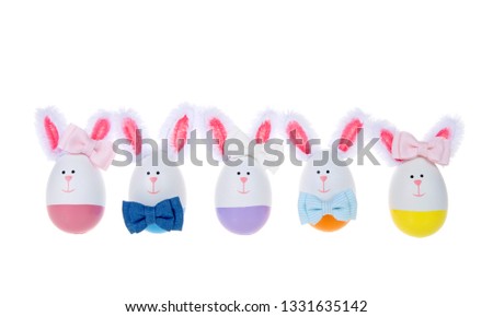 Row of Easter Eggs crafted into bunnies, boys and girls, wearing bow ties and bows on ear lined up isolated on white background.