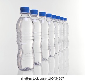 Row Of Eight Water Bottles Disappearing Into Distance With Focus On Front Bottles