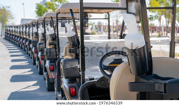 A row of electric golf carts on a golf course.\
Selective Focus