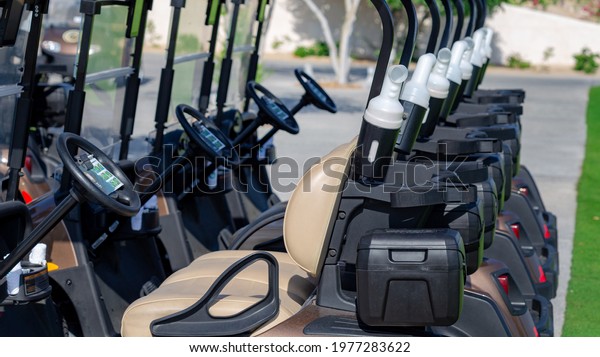 A row of electric golf carts on a golf course.\
Selective Focus