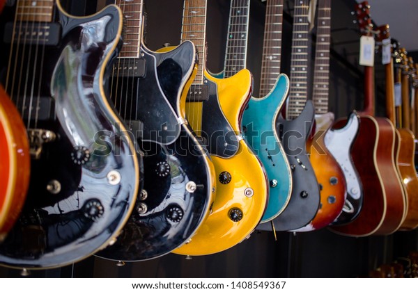 Row of electric guitars In a music\
instruments shop. Parts of guitar, guitar\
body