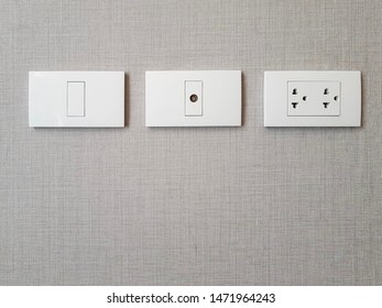 Row Of Electric Outlet Set In Bedroom Wall, TV Outlet , Cable Outlet And Electronic Plug With Asia Style On Grey Fabric Texture Wallpaper, Cable Television. Electricity Concept.