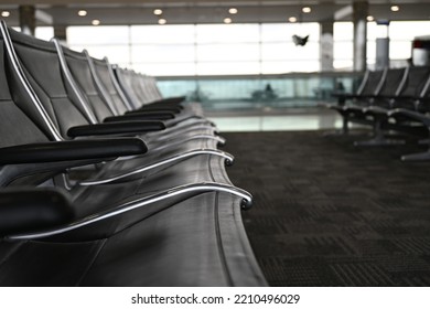 Row Of Empty Blue Chairs In Major Airport For Passenger To Sit Between Flights. Seats In Boarding Area Of A Terminal