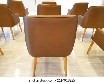 Row of empty brown chairs in back side at a serviced counter