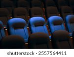 
Row of Empty Chairs in a Movie Theater before Show Begins 
Theater with rows of chairs ready to receive spectators
