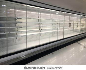 Row of empty commercial fridges at grocery store.