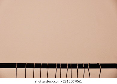 Row of Empty Hanger Hooks on Clothing Rail with Large Copy Space