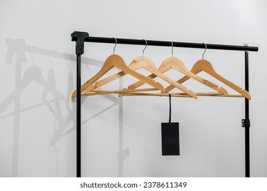 Row of empty hangers on the rack. Wooden coat hanger with blank tag against white background. Store concept. Advertising of Black Friday sales